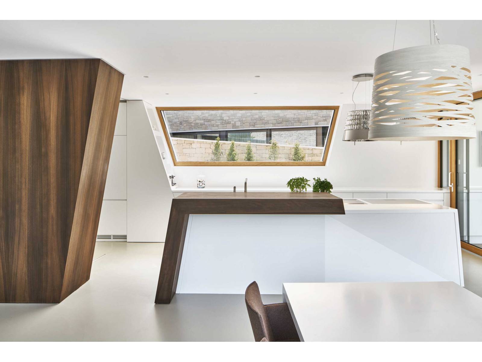 Die einzelnen Küchenelemente von «Coloralaccato», die in unterschiedlichen Winkeln angeordnet sind, erzeugen Spannung, aber auch schlichte Eleganz. Die kraftvolle Inszenierung wird durch das Aufeinandertreffen von naturbelassener Räuchereiche, weissen Lackfronten und der farblich abgestimmten Mineralabdeckung verstärkt. MOVANORM.