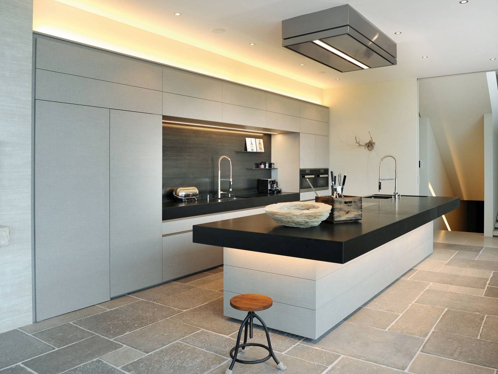 Die Kombination von clever eingesetzten Lichteffekten und spannenden Materialien wird hier zum Eyecatcher, wie zum Beispiel die offene, mit LED beleuchtete Nische mit Spülcenter, die mit Schwarzstahl ausgekleidet ist, oder die Unterleuchtung des massiven Küchenblocks, der dadurch fast zu schweben scheint. Brunner Küchen.