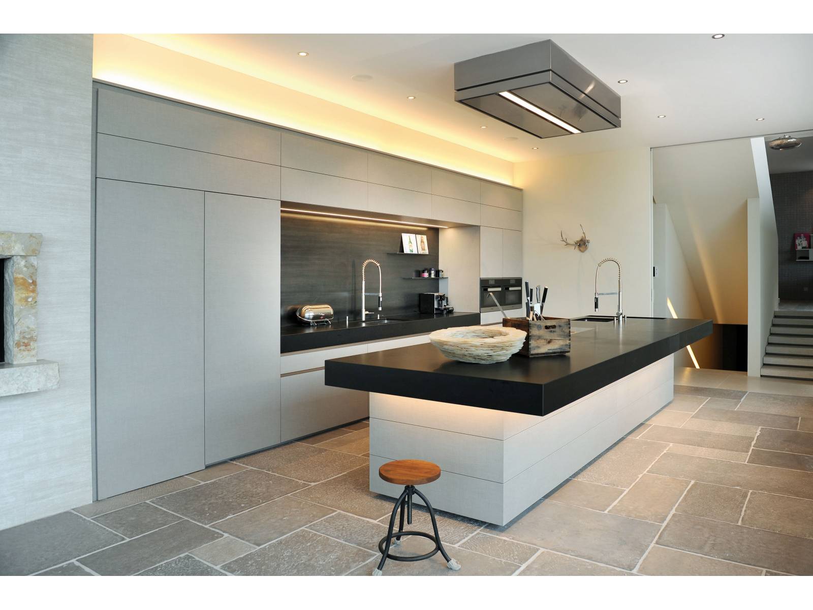 Die Kombination von clever eingesetzten Lichteffekten und spannenden Materialien wird hier zum Eyecatcher, wie zum Beispiel die offene, mit LED beleuchtete Nische mit Spülcenter, die mit Schwarzstahl ausgekleidet ist, oder die Unterleuchtung des massiven Küchenblocks, der dadurch fast zu schweben scheint. Brunner Küchen.