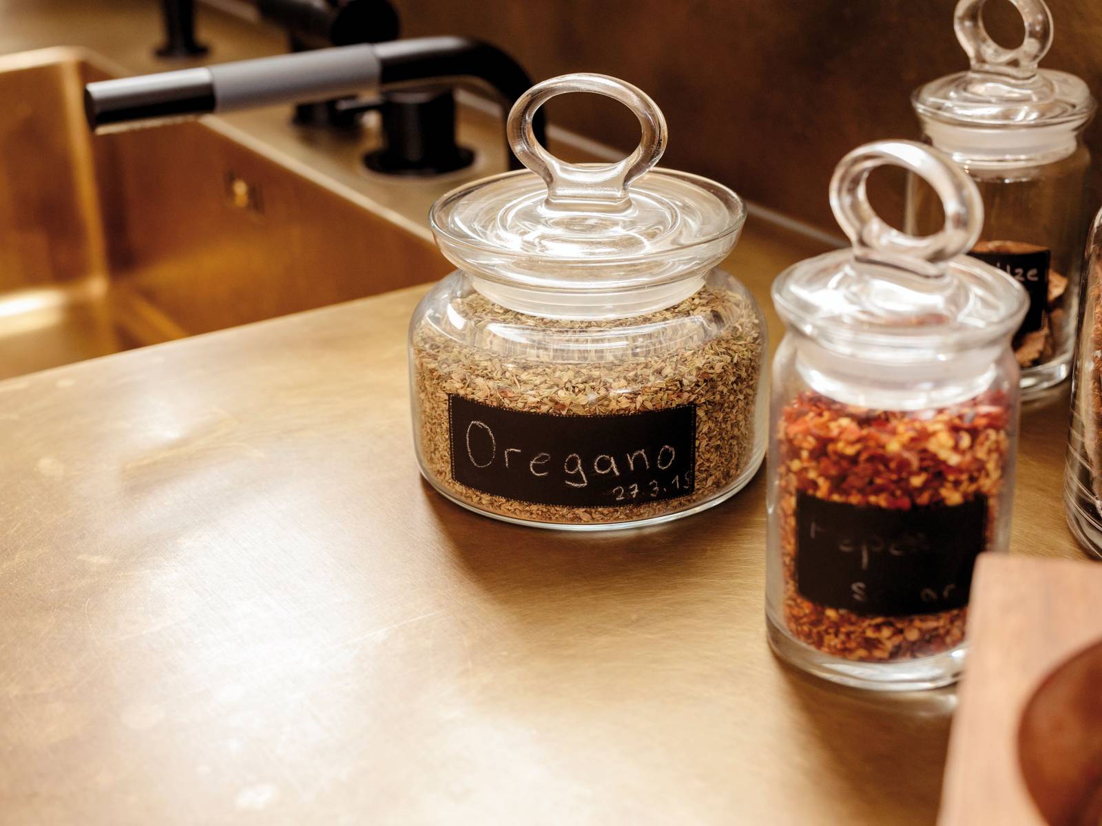 Eine Arbeitsfläche inklusive Spültrog aus gebürstetem Messing verleihen dieser Küche einen edlen Touch. Durch die Kombination mit den dunklen Armaturen entsteht ein reizvoller Kontrast, der durch anthrazitfarbene Fronten noch hervor gehoben wird. Herzog Küchen.