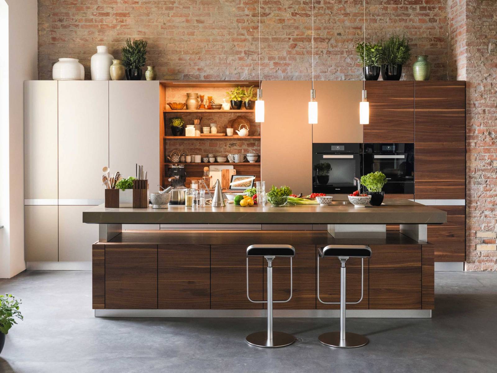 Kochvergnügen beginnt bei der Ergonomie: Die Kochinsel «K7» lässt sich dank einer patentierten Hubtechnologie stufenlos verstellen und macht in ihrer Funktion als Tisch, Bar oder Arbeitsfläche mit einer variablen Höhe von 74 bis zu 114 Zentimetern eine gute Figur. Team 7.