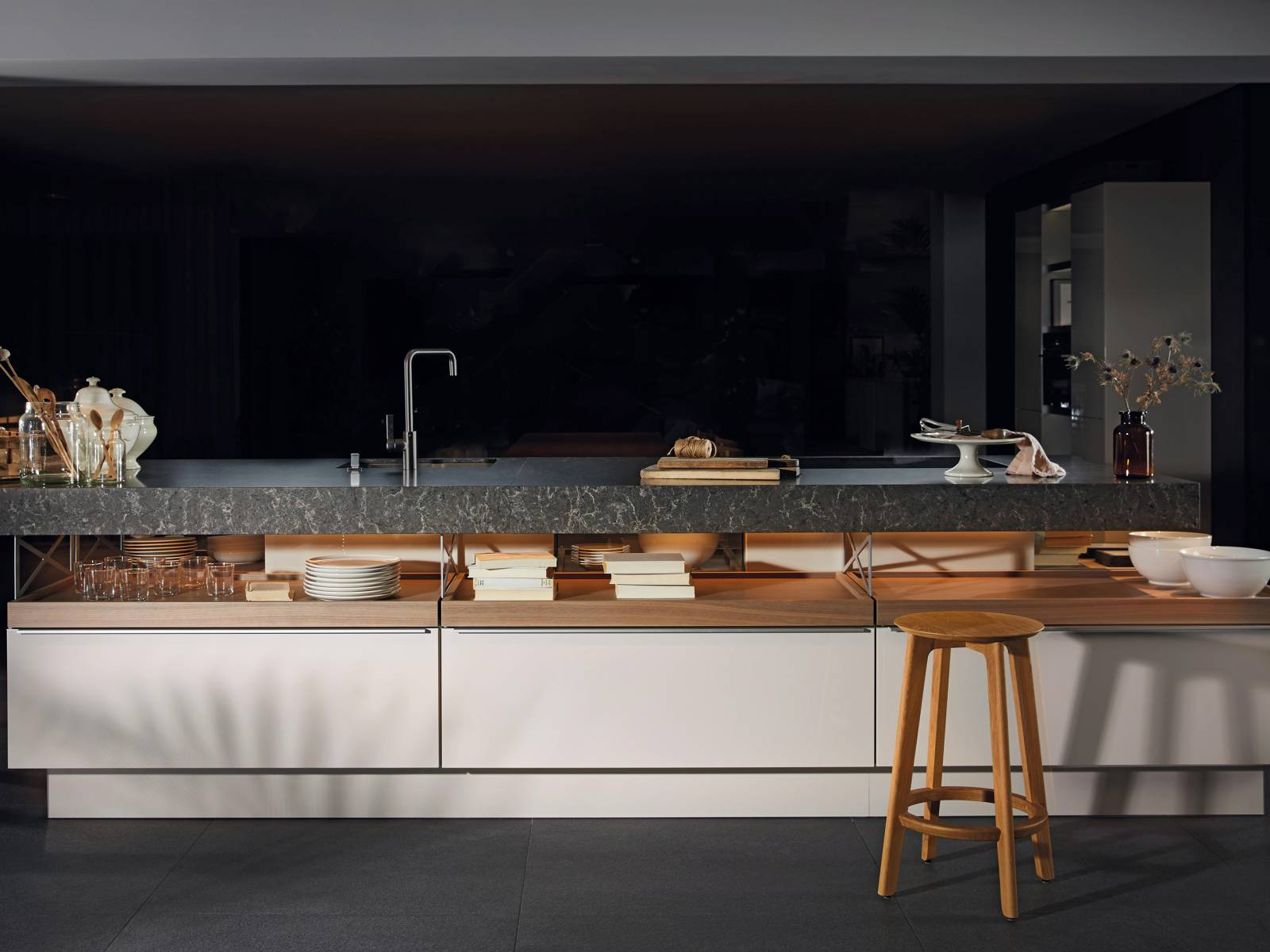 Die Küche «+Modo» ist der Beweis dafür, dass Gegensätze in Harmonie enden können. Ihr Designer Jorge Pensi spielt mit der Inszenierung offener und geschlossener Funktionsbereiche und schafft es, den schwer wirkenden Materialien dank eines ansprechenden Beleuchtungskonzepts Leichtigkeit zu verleihen. Poggenpohl.