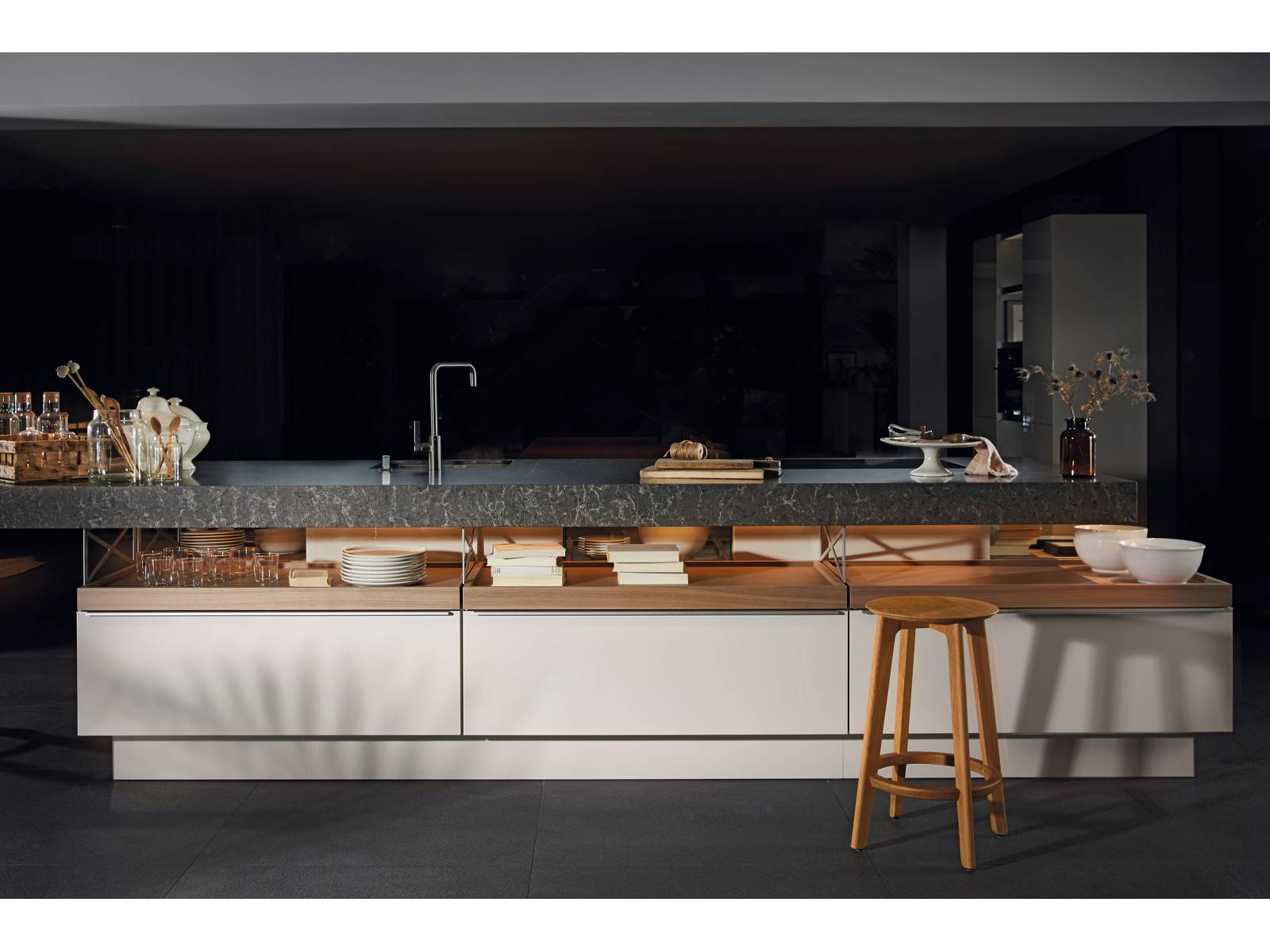 Die Küche «+Modo» ist der Beweis dafür, dass Gegensätze in Harmonie enden können. Ihr Designer Jorge Pensi spielt mit der Inszenierung offener und geschlossener Funktionsbereiche und schafft es, den schwer wirkenden Materialien dank eines ansprechenden Beleuchtungskonzepts Leichtigkeit zu verleihen. Poggenpohl.