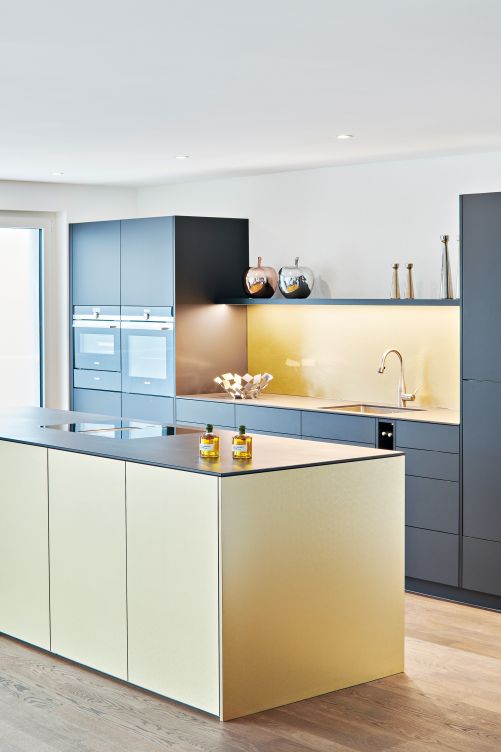 Es ist tatsächlich Gold, das hier glänzt und diese Küche zu einem ganz besonderen Hingucker macht: In perfekter Harmonie mit der zurückhaltenden Optik der dunklen Oberflächen in Damast setzt sie ein stilvolles Statement. Brunner Küchen.