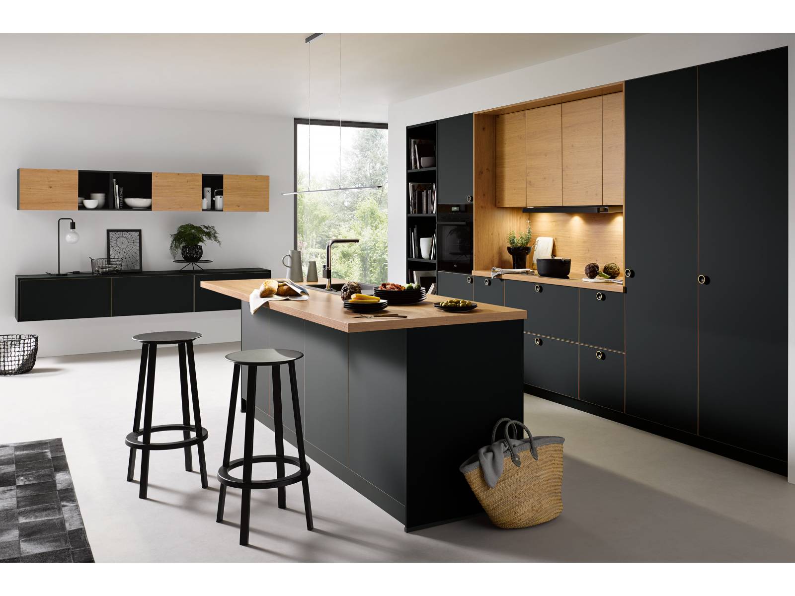 Wie ruhig und behaglich matte Fronten wirken, zeigt der Küchenhersteller mit «Strato matt». Die kühle Eleganz der schwarzen Fronten erhält durch fein abgestimmte Akzente in Holznachbildung die nötige Wärme: Die Holzflächen der Oberschränke wiederholen sich in Dekorkanten und Knopfgriffen und schaffen so eine Verbindung zwischen den gegensätzlichen Materialien. Damit man nicht ständig putzen muss, ist die neue Front mit einer innovativen Anti-Fingerprint-Technologie ausgestattet. Schüller.