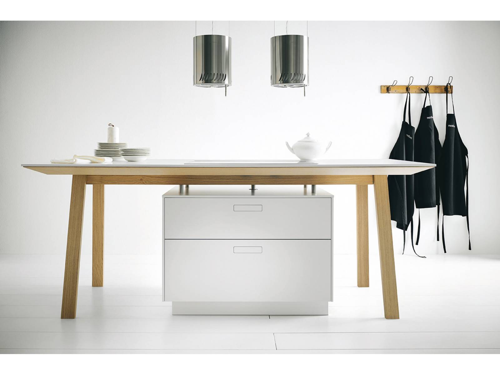 Der Kochtisch kombiniert zwei elementare Bestandteile der Küche, die Kücheninsel und den Esstisch. Die Idee dahinter: Gäste sollen nicht mehr einfach nur zum Essen kommen, sondern sich am gemeinsamen Kochprozess beteiligen. Die Premiummarke des fränkischen Küchenherstellers Schüller folgt dem bekannten Bauhaus-Stil und gestaltet ihre Objekte möglichst minimalistisch, funktional und zeitlos. Mit dem Kochtisch kommt das Unternehmen dem Ziel, Design-Klassiker der Neuzeit zu schaffen, ein ganzes Stück näher. Next125.