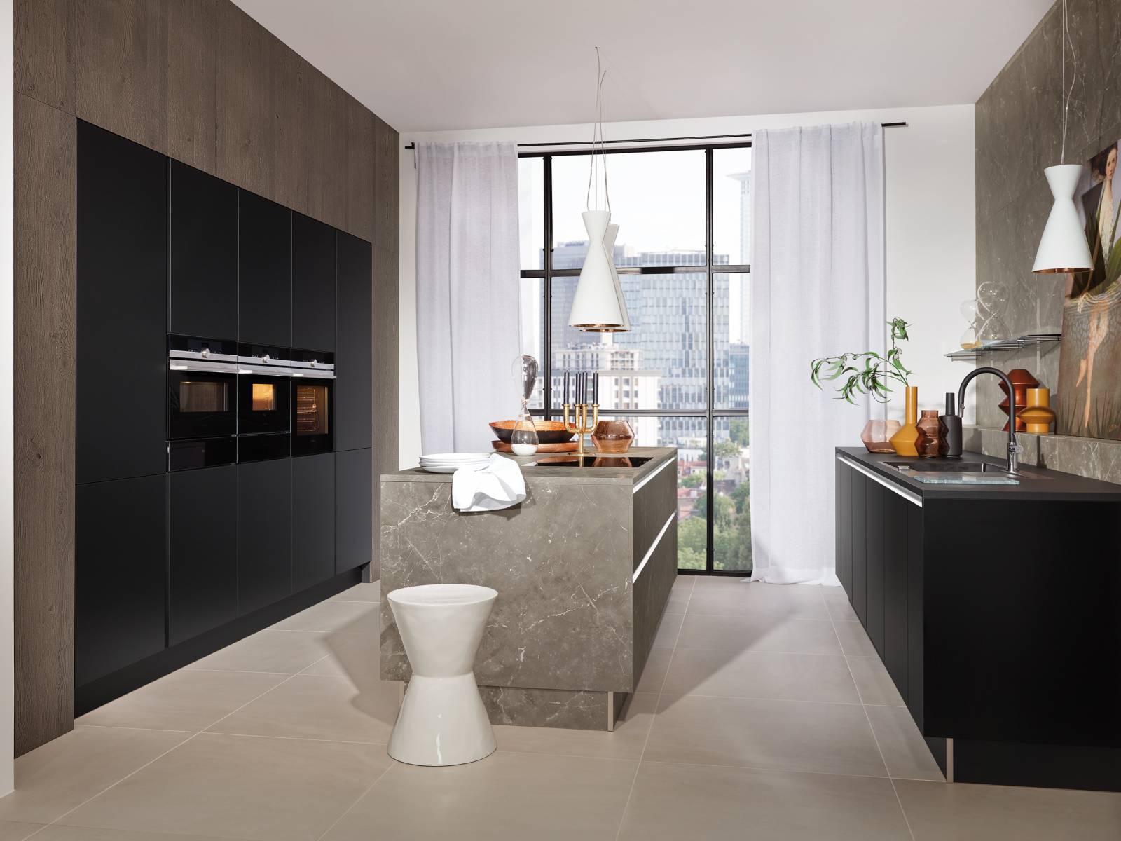 «Manhattan» greift das Trendthema Marmor auf und setzt es in der Küche um. Das graue Marmor-Dekor ist vielseitig und wirkt besonders edel, wenn man es mit schwarzen Fronten kombiniert. Passend dazu präsentiert der Küchenhersteller optional beleuchtete Regale mit schwarzen Glasböden sowie flächenbündig eingebaute Spülen und Kochfelder. Nolte.