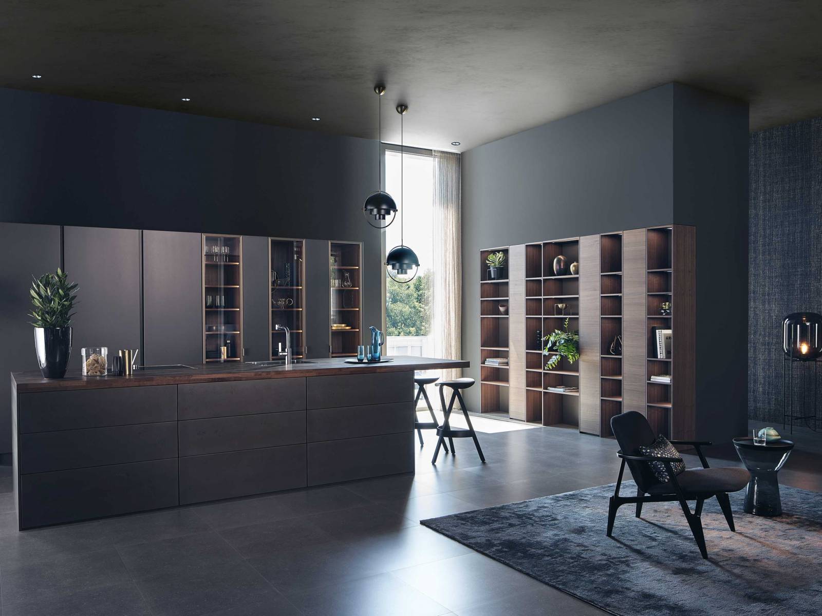 Das Küchensortiment des Unternehmens umfasst unter anderem Linien der Marke Leicht. Dieses Beispiel hier zeigt eine Version mit metallbeschichteten Oberflächen, Echtholzfronten und Glasvitrinen. DIPL. ING. FUST.