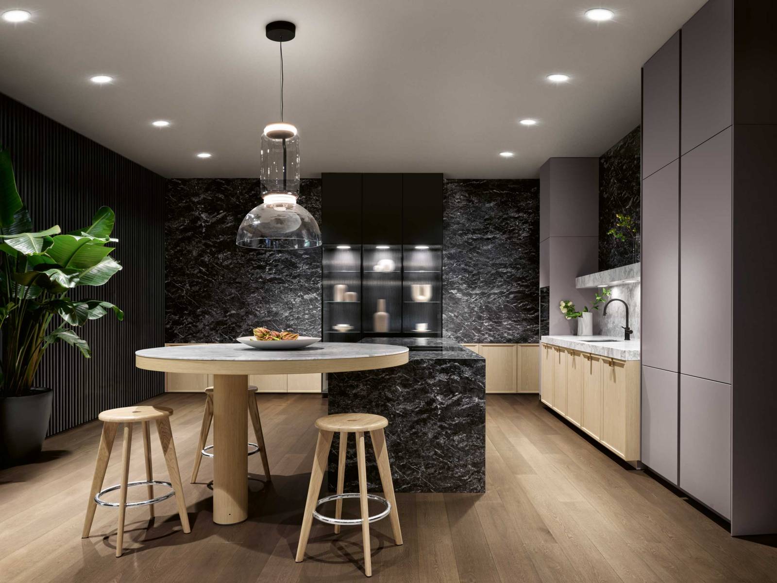 Für «Mondial» hat sich der deutsche Küchenhersteller intensiv mit dem Thema Luxus auseinandergesetzt. Die neue Stilwelt, die in Mailand zum ersten Mal präsentiert wurde, ist opulent, ohne dabei traditionell zu sein. Markanter Kalkstein prägt den zentralen Monoblock der Kochinsel; asymmetrisch auskragend ruht darauf ein runder Bartisch aus Quarzit. Foto: Franz Gruenewald. SIEMATIC.