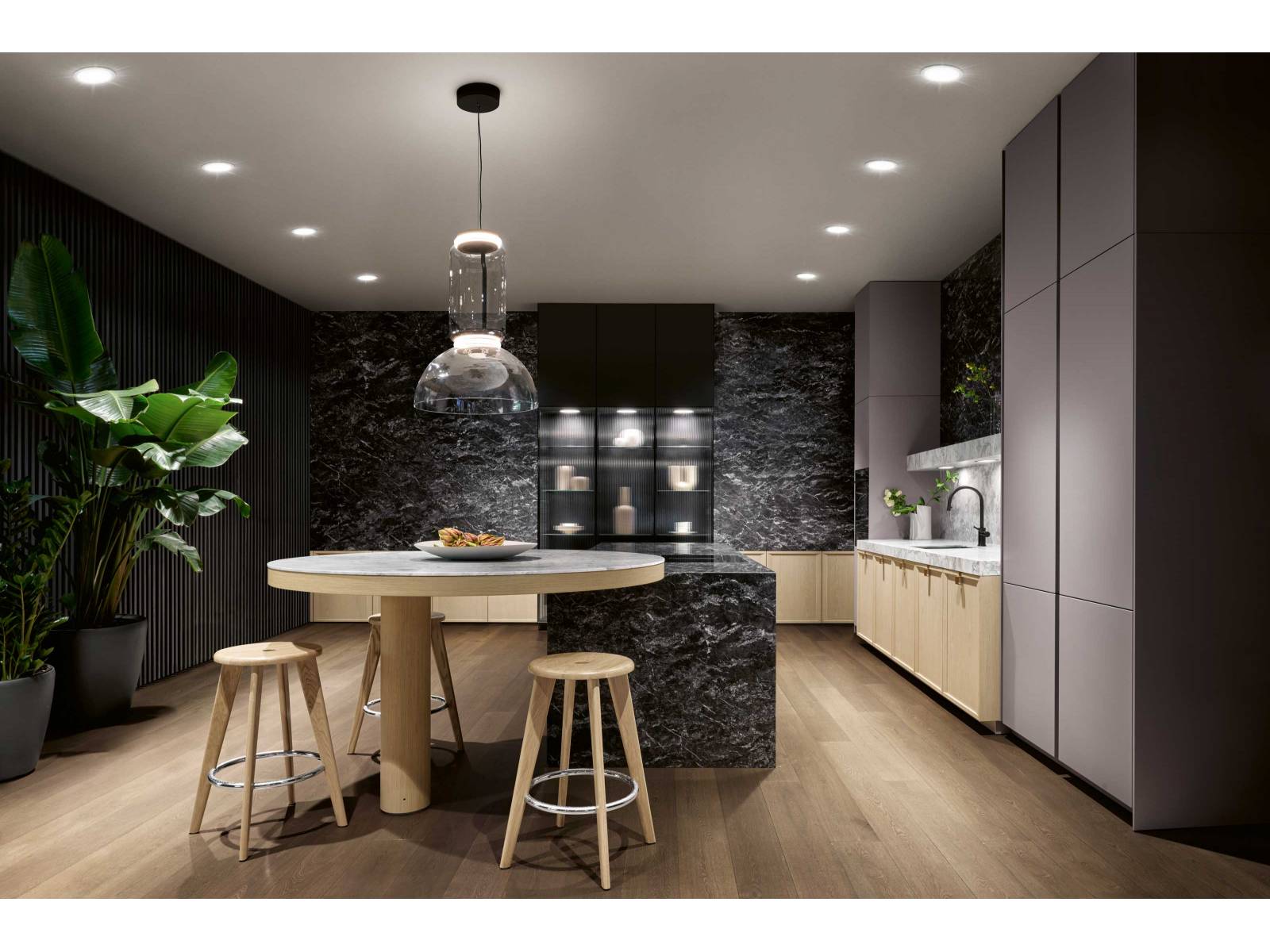 Für «Mondial» hat sich der deutsche Küchenhersteller intensiv mit dem Thema Luxus auseinandergesetzt. Die neue Stilwelt, die in Mailand zum ersten Mal präsentiert wurde, ist opulent, ohne dabei traditionell zu sein. Markanter Kalkstein prägt den zentralen Monoblock der Kochinsel; asymmetrisch auskragend ruht darauf ein runder Bartisch aus Quarzit. Foto: Franz Gruenewald. SIEMATIC.