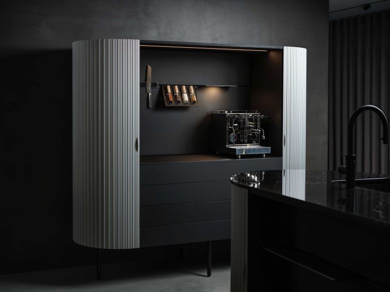 Eine bewegliche Rollfront «Wogg 75 Patent System» aus Aluminium umschliesst die Küchenmöbel. WOGG.CH