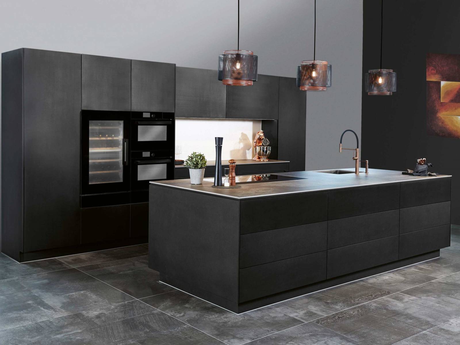 Die Küchenmöbel aus der Serie «Infinity» werden in Eigenproduktion aus Swiss-CDF-Faserplatten hergestellt, deren Holz aus nachhaltig bewirtschafteten Schweizer Wäldern stammt. Die kupferfarbenen Armaturen setzen gezielt Glanzpunkte zwischen den schwarzen Fronten und verleihen der Küche eine besondere Eleganz. SABAG.