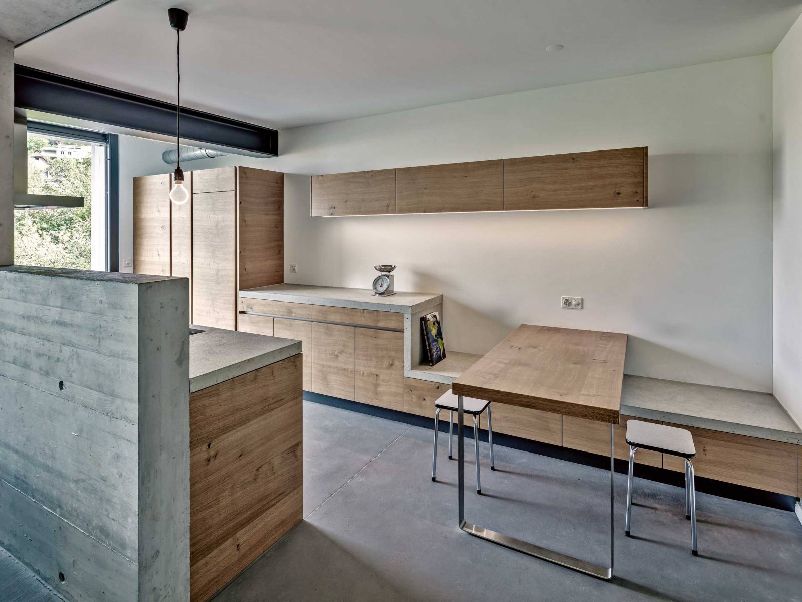 Die moderne Betonküche setzt ganz auf geometrische Formen und eine reduzierte Materialisierung. Sie ist ein Teil der Architektur, wirkt trennend und ist doch in den Wohnraum integriert. Beton und Holz bilden eine stimmige Kombination und sorgen für eine angesagte, monochrome Optik. BRUNNER-KUECHEN.