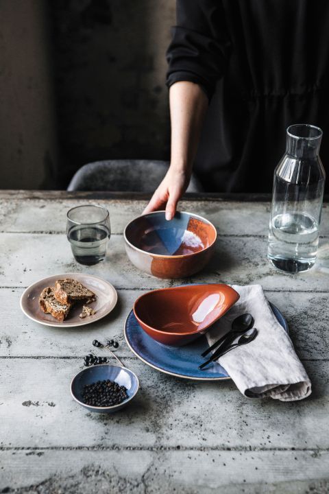 Das nie ganz einheitliche, da von Hand glasierte Service «Homestyle» erinnert an Steingut aus früheren Zeiten. Rund um die mehrfarbige Schale bzw. Platte gibt es ein breites Sortiment unifarbener Teller, Tassen und Schälchen. Kahla Porzellan.