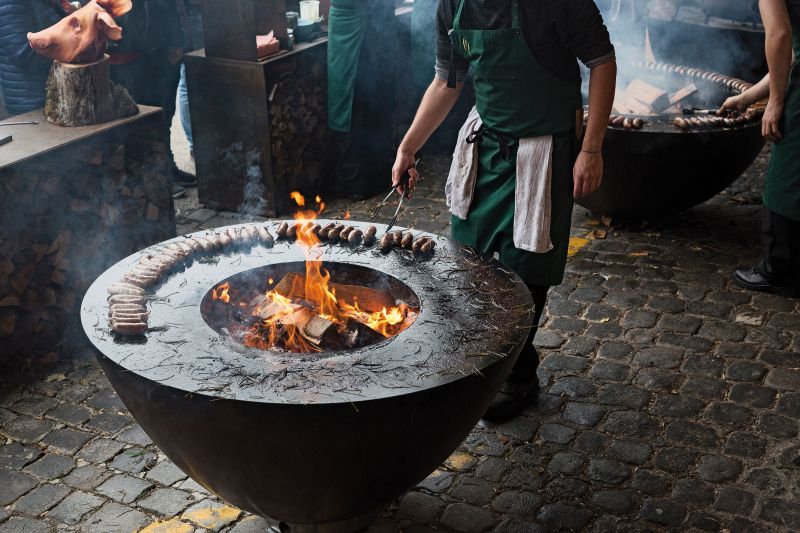 Der Schweizer Hersteller von grossen, reduzierten Stahlblech-Feuerschalen, auf denen man grillen kann, präsentierte sich rund um die Alte Mühle. Die BesucherInnen waren aufgefordert, die schweren Schalen in einer Art Hochregallager aus neuen Blickwinkeln zu betrachen. Stefan Wiesner, ein prämierter Spitzenkoch, grillte auf mehreren Feuerringen und zeigte eine unerwartete, fast provokative Produktionskette vom Schwein zur Wurst. Feuerring / Stefan Wiesner.