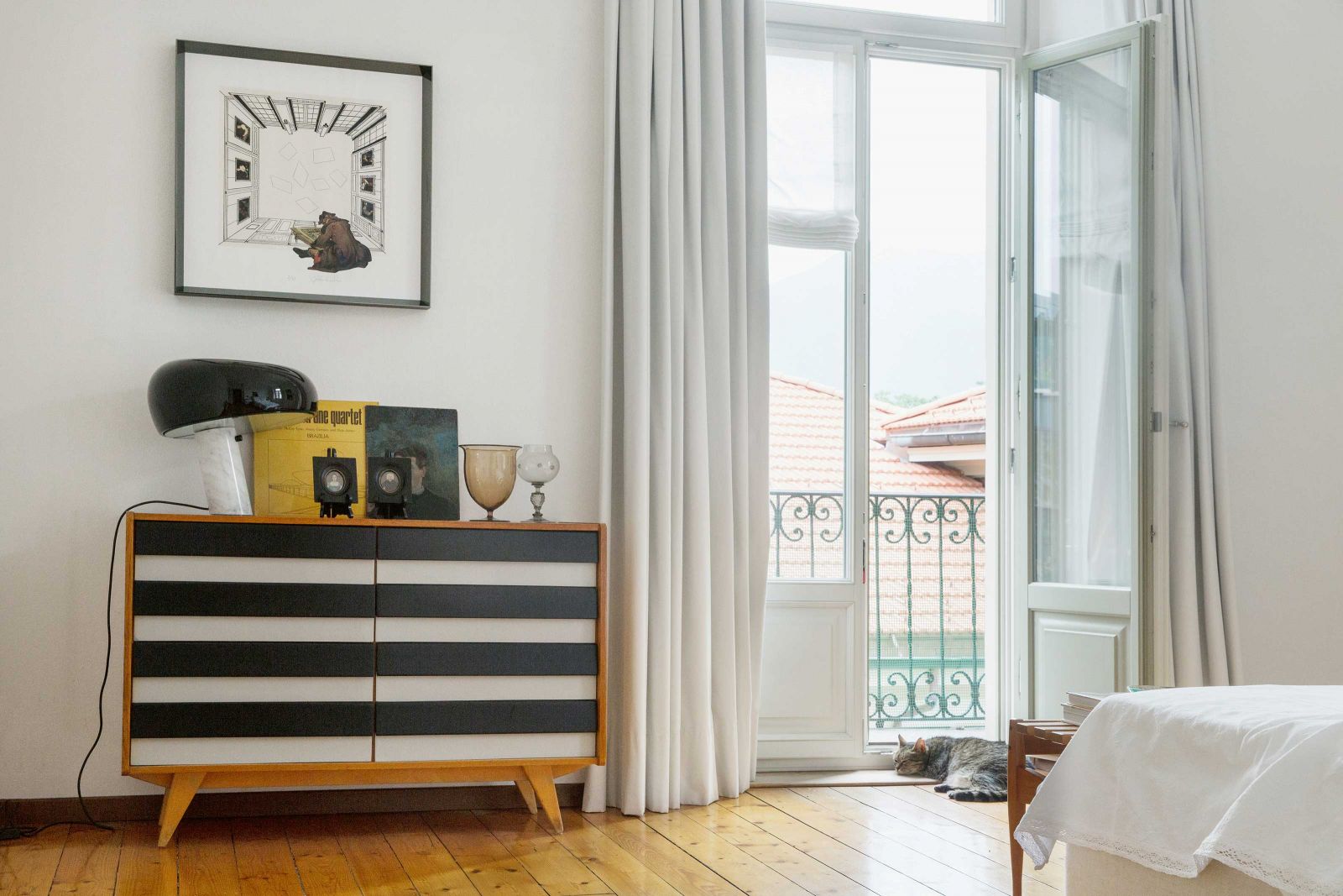 Im Schlafzimmer trifft tschechisches Design auf italienische Klassiker: Leuchte «Snoopy» von Achille Castiglioni und Pier Giacomo für Flos; Kommode von Jiri Jiroutek für Interier Praha.