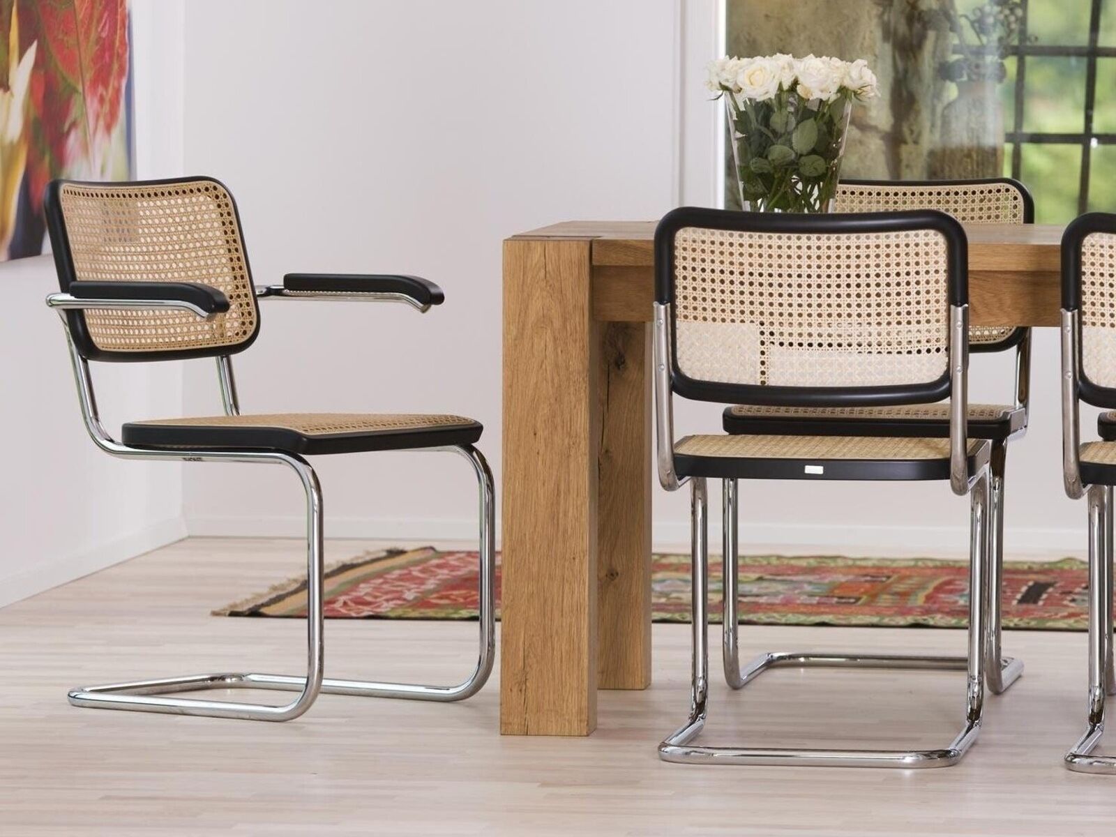 Ein eleganter Thonet-Freischwinger, der neben dem Holztisch ein stilvoller Blickfang ist. Foto: © Thonet / Ambientedirect