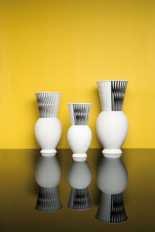 Die Tapete, entstanden nach Originaldesigns von Bauhaus Absolventen, gibt das geometrisch anmutende Muster auf der Reedition der Vasenkollektion Halle vor. Letztere ist ein Entwurf der Bauhausschülerin und späteren Werkstattmeisterin Marguerite Friedlaender aus dem Jahr 1931. KPM Berlin & Tapetenfabrik Gebrüder Rasch.