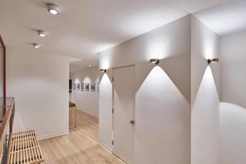 Das Spiel aus Licht und Schatten der Leuchte «Sento verticale» an den Wänden verleiht dem Flur Dynamik. Ochhio.