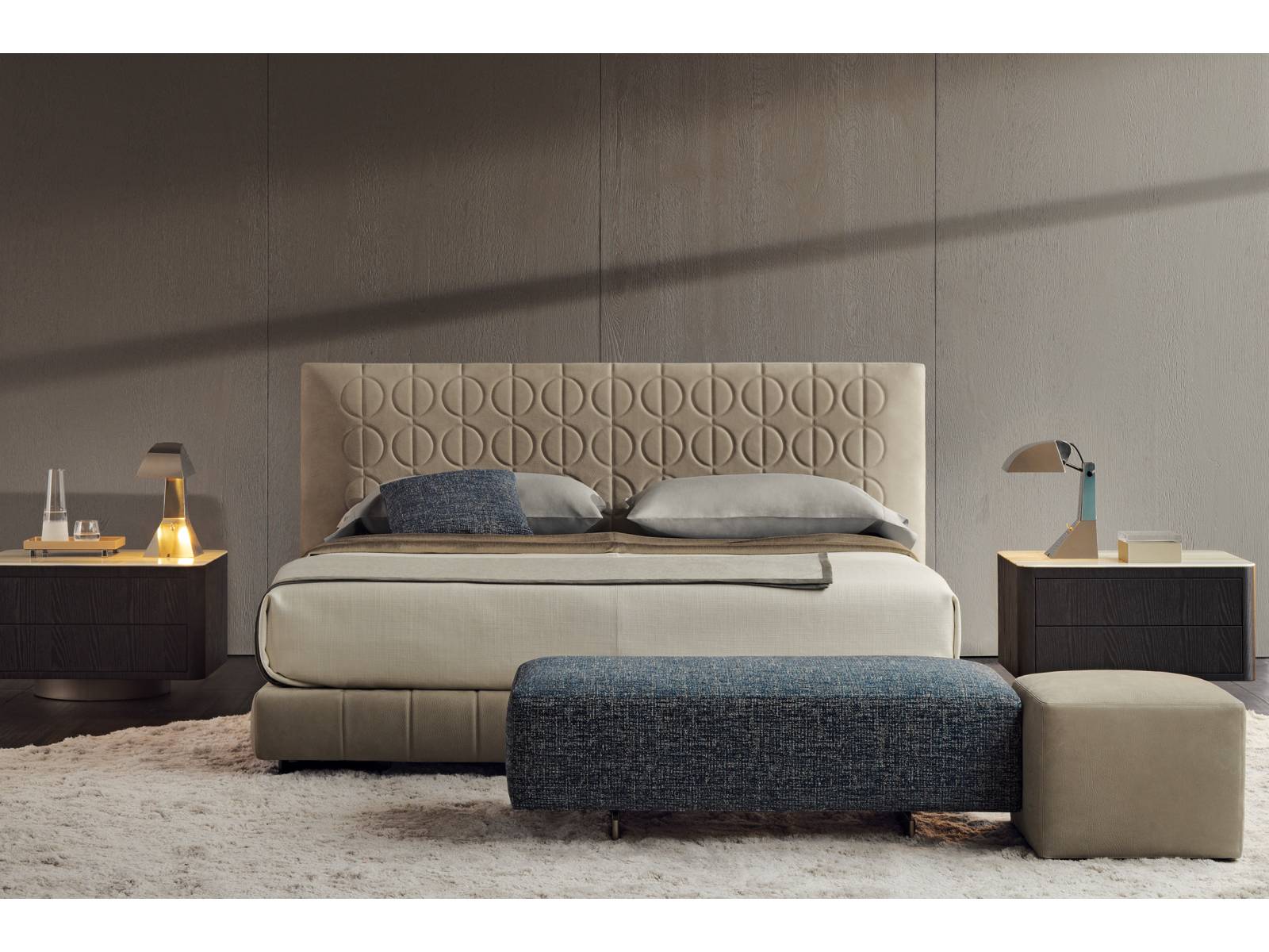 Steppmuster mal anders: Hier zieren Kreise, die von einer vertikalen Linie durchlaufen werden, das exklusive und hohe Kopfteil von Bett «Curtis». Die Linien werden im Bettgestell wieder aufgenommen. Den Bezug gibt es in Stoff oder Leder. Design: Rodolfo Dordoni. Minotti.