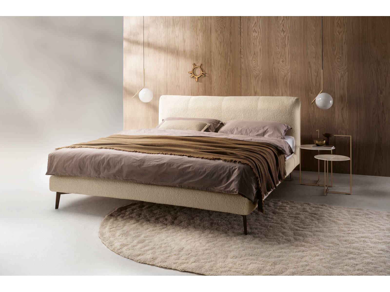 Der Komfort der filigranen Box sowie die Üppigkeit des weichen Kopfteils machen das Bett «Francis» mit dem hellen Bouclé-Stoff zu einem eleganten Rückzugsort. Für eine schwebende Optik sorgen die abgestimmten Metallfüsse. MÖLLER DESIGN.