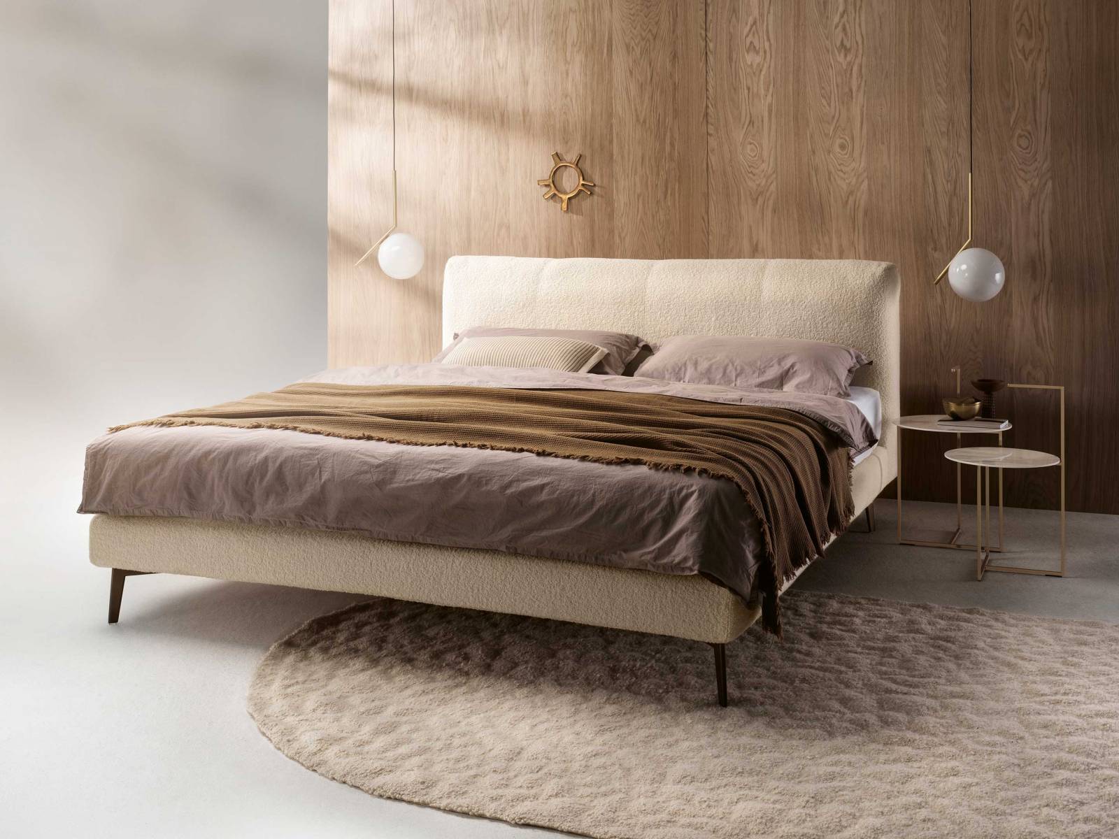 Der Komfort der filigranen Box sowie die Üppigkeit des weichen Kopfteils machen das Bett «Francis» mit dem hellen Bouclé-Stoff zu einem eleganten Rückzugsort. Für eine schwebende Optik sorgen die abgestimmten Metallfüsse. MÖLLER DESIGN.