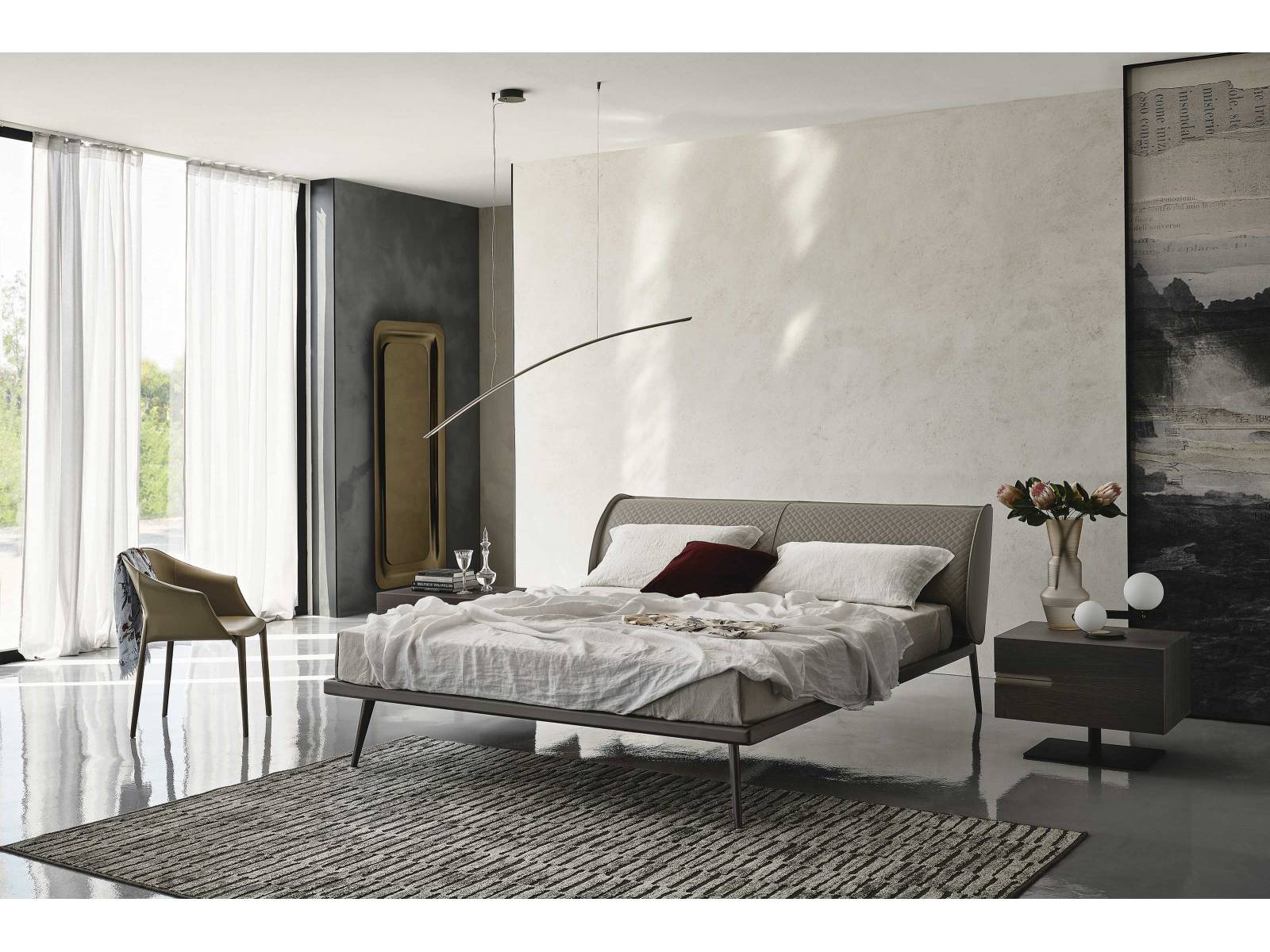 Das Bett «Ayerton» steht auf einem Stahlrahmen, der in Titan oder Bronze lackiert ist und zusammen mit dem Kopfteil in Stoff, synthetischem Nubuk, Kunst- oder Softleder eine elegante Kombination bildet. Cattelan.