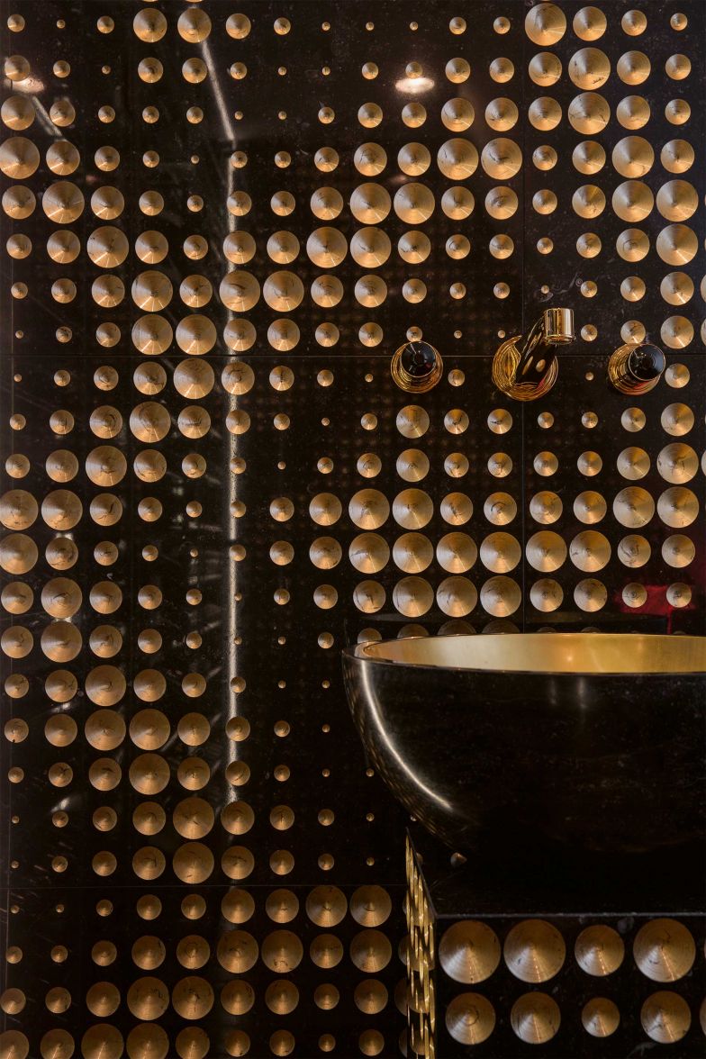 Alles ausser gewöhnlich ist diese dunkle Wandverkleidung mit exklusivem Naturstein der Kollektion «Luxury» von Lithos Design, in den unterschiedlich grosse Vertiefungen eingraviert und mit Blattgold beschichtet wurden. STONEGROUP.CH