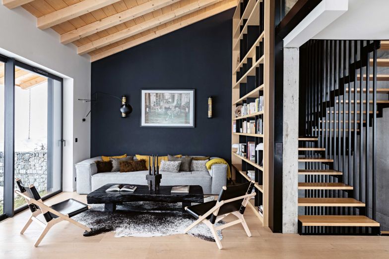 Die dunkle Wand hinter dem lässigen Sofa schafft einen Raum im Raum und bildet einen schönen Hintergrund für das gerahmte Foto von Dominique Tarlé. Sofa «Cosima»: Bolia; Couchtisch: Atmosphère d'Ailleurs; Wandleuchte «In the Tube»: DCW Éditions; Sessel: Les Montagnardes.