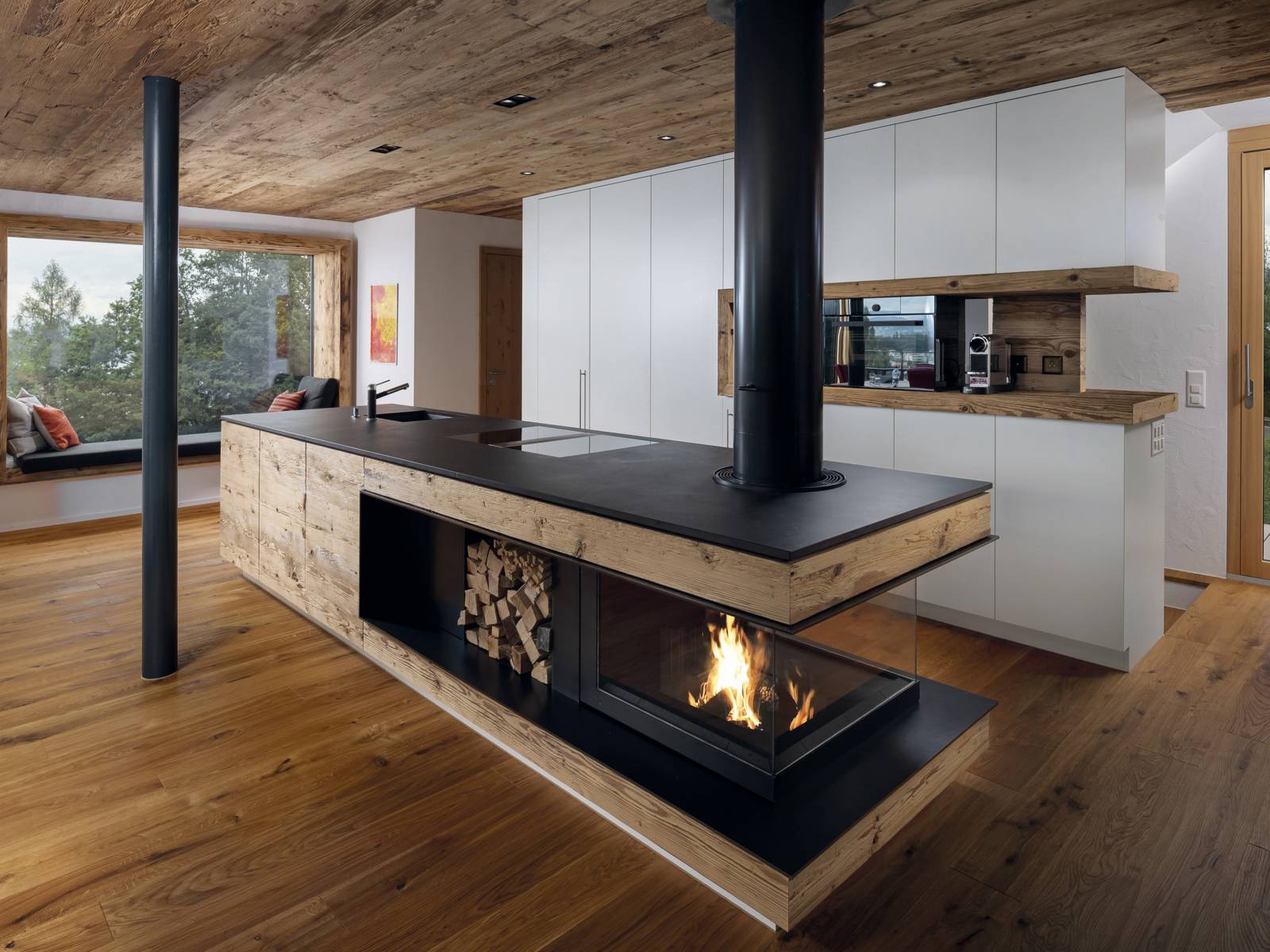 Das Unternehmen plant, entwickelt und stellt seit Jahren individuell gefertigte Feuerstellen her, die mit viel Liebe zum Detail in einheimischen Werkstätten gefertigt werden. In diesem Beispiel hier wurde die Feuerstelle in der Kücheninsel integriert und ist so konzipiert, dass trotzdem in der Küche möglichst wenig Hitze entsteht, dafür aber eine wohlige Atmosphäre geschaffen wird. Wirth & Schmid.