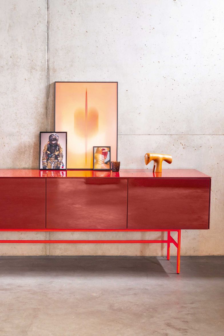 Mit Neongelb und Leuchtrot bei Gestellen und Griffen erweitert der deutsche Hersteller seine Farbpalette um zwei Töne, die auffälliger nicht sein könnten. Bei dieser Variante des Sideboards «Soma» bringt das Fussgestell in Leuchtrot die gedeckteren Fronten, für die man unter 24 Lackoberflächen, sechs Holzfurnieren sowie weiteren Materialien wie Fenix oder Aluminium wählen kann, erst richtig zur Geltung. Foto: Ingo Rack. KETTNAKER.COM