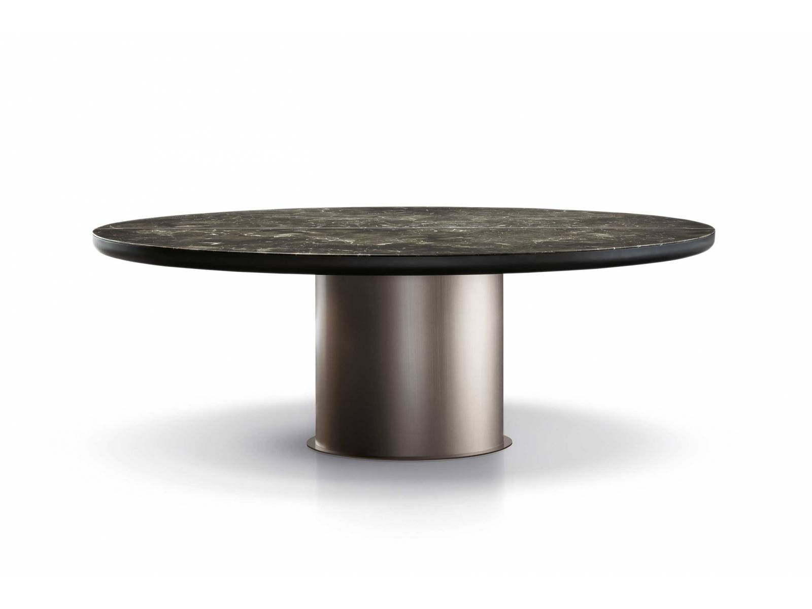 Das gewölbte, linsenförmige Untergestell des Tisches «Brady Dining» nimmt die Marmorplatte wie einen Stein auf, der in ein Schmuckstück gefasst ist. Der zylindrische Sockel ist in Bronze oder Mokka erhältlich. MINOTTI.