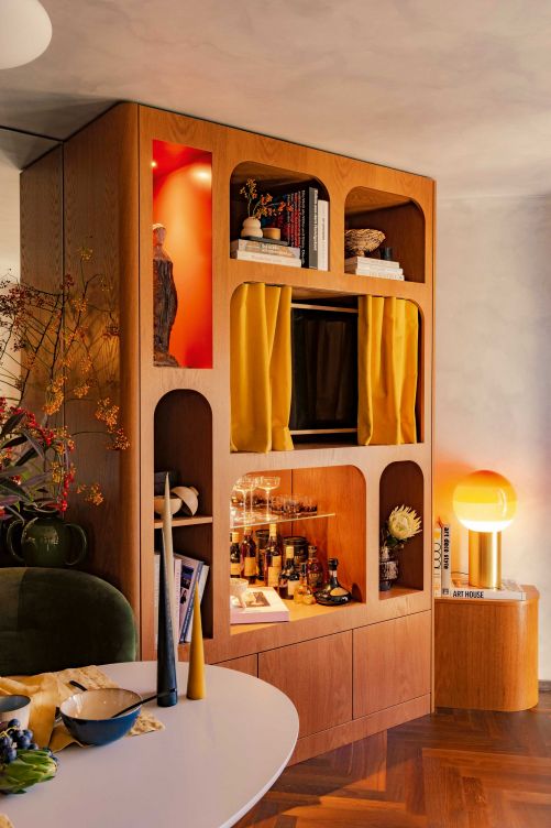 Die Wohnwand aus Schweizer Eiche bietet Stauraum, aber auch Platz, um sorgfältig ausgesuchte Accessoires in Szene zu setzen. Tischleuchte: «Dipping» von Marset. Sämtliche Holzarbeiten wurden von der Firma Kissling AG aus Reiden ausgeführt.