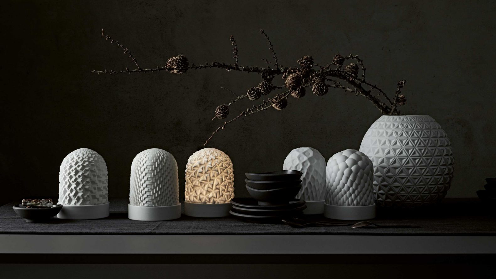 Geometrie ins Licht gesetzt: Verschiedene geometrische Muster bei den LED-Tischleuchten «Phi» überziehen die weissen Porzellankörper und lassen diese bei Licht als wunderschöne Blüten, Kristalle und Schneeflocken erscheinen. Design: Cairn Young. Rosenthal.