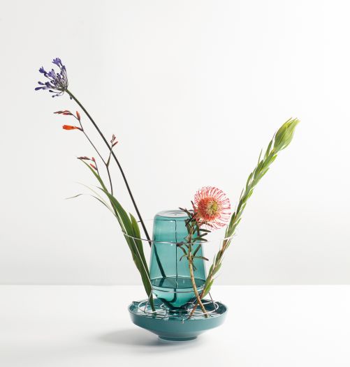 Warum einfach, wenn es auch ausgefallen geht? Diese Vase hier besteht nicht nur aus einem Gefäss, sondern liegt in einer Halterung aus Edelstahl, die wiederum auf einem Teller aus Keramik steht, was zusammen zu einer Kulisse für ungewöhnliche Blumenarrangements wird. Valerie Objects.