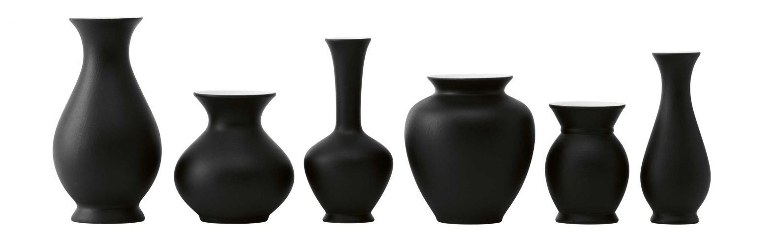 Wie kleine Kunstobjekte wirken die sechs Vasen der Kollektion «Blossom». Das Set aus Biskuitporzellan gibt es künftig nicht nur in Weiss, sondern auch in Schwarz mit weisser Innenseite. Sie können einzeln auf dem Frühstückstisch oder gruppiert auf einer grösseren Tafel dekoriert werden, aber auch ohne Inhalt als Objekt im Regal stehen. SCHOENBUCH.