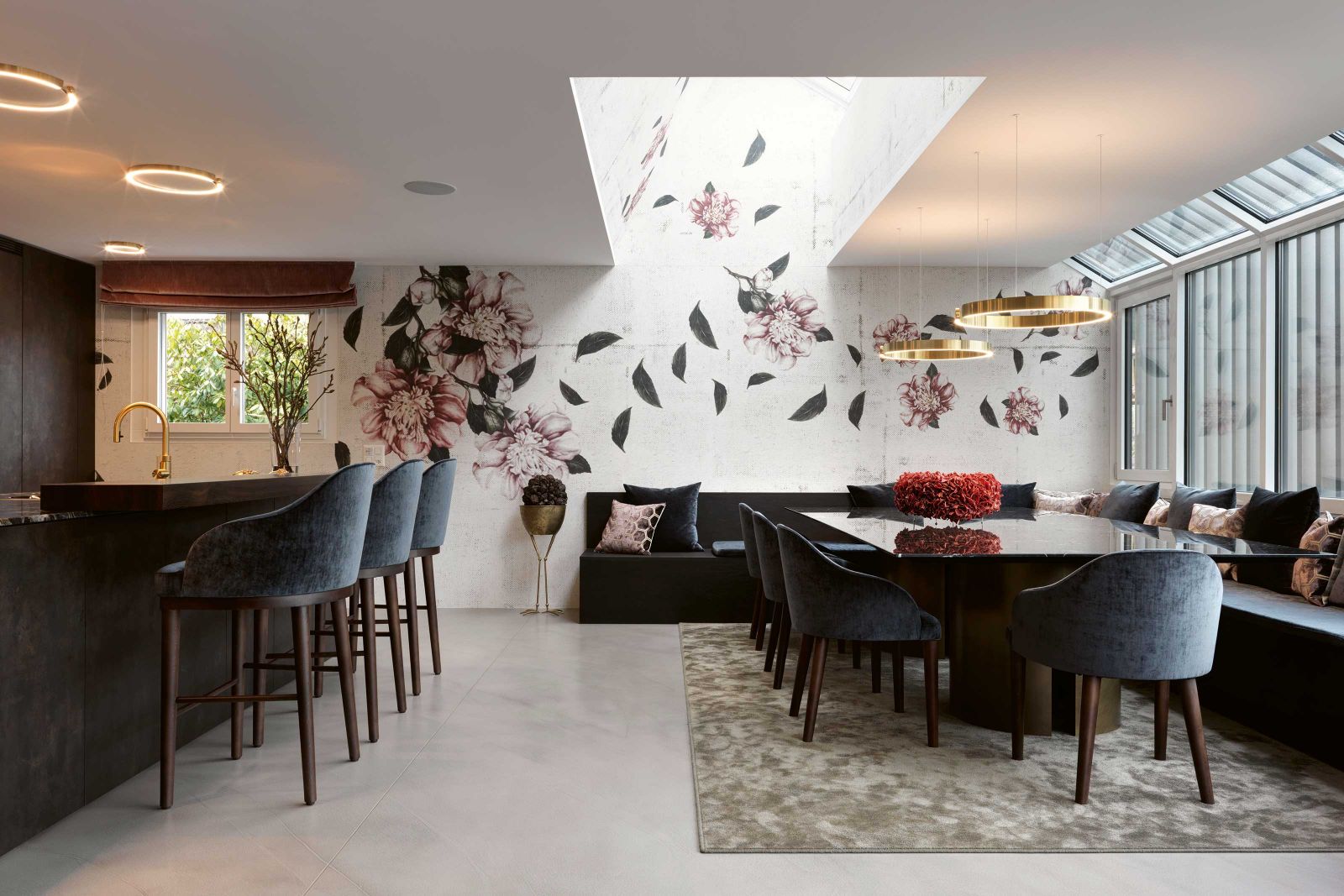 Da Familie Emmenegger auch einen Garten besitzt, wurde die 30 Quadratmeter grosse Terrasse zum offenen Ess- und Küchenbereich umgestaltet. Den Blumentrog, der wie ein Band rund um den Aussensitzplatz lief, liess Karin Grossenbacher zur Sitzbank umfunktionieren. Blütentapete: «Cascade» von Wall & Deco; Esstisch «Gong» von Meridiani; Stühle: Al Lago Interiors; Textilien und Bezugsstoffe: Designers Guild; Leuchten: Occhio.