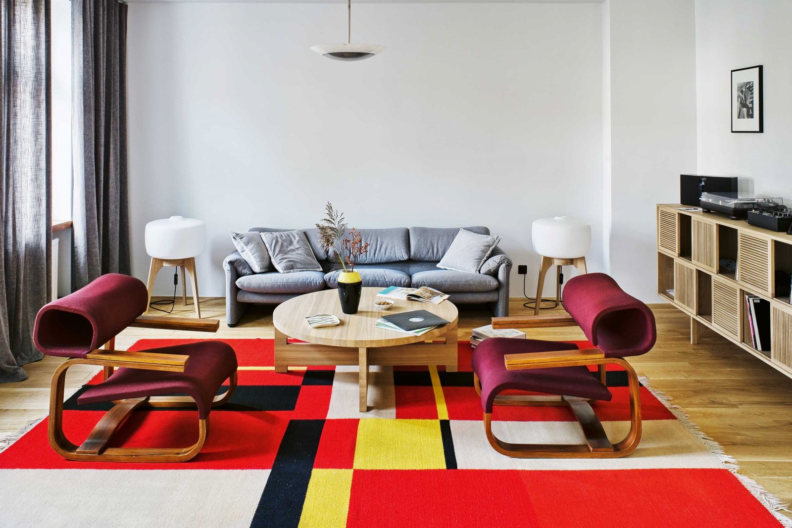 Der Wollteppich im kubistischen Stil, der an die Werke Piet Mondrians erinnert, fungiert als optische Klammer für die beiden geschwungenen Sessel des Prager Architekten Jan Bocan.