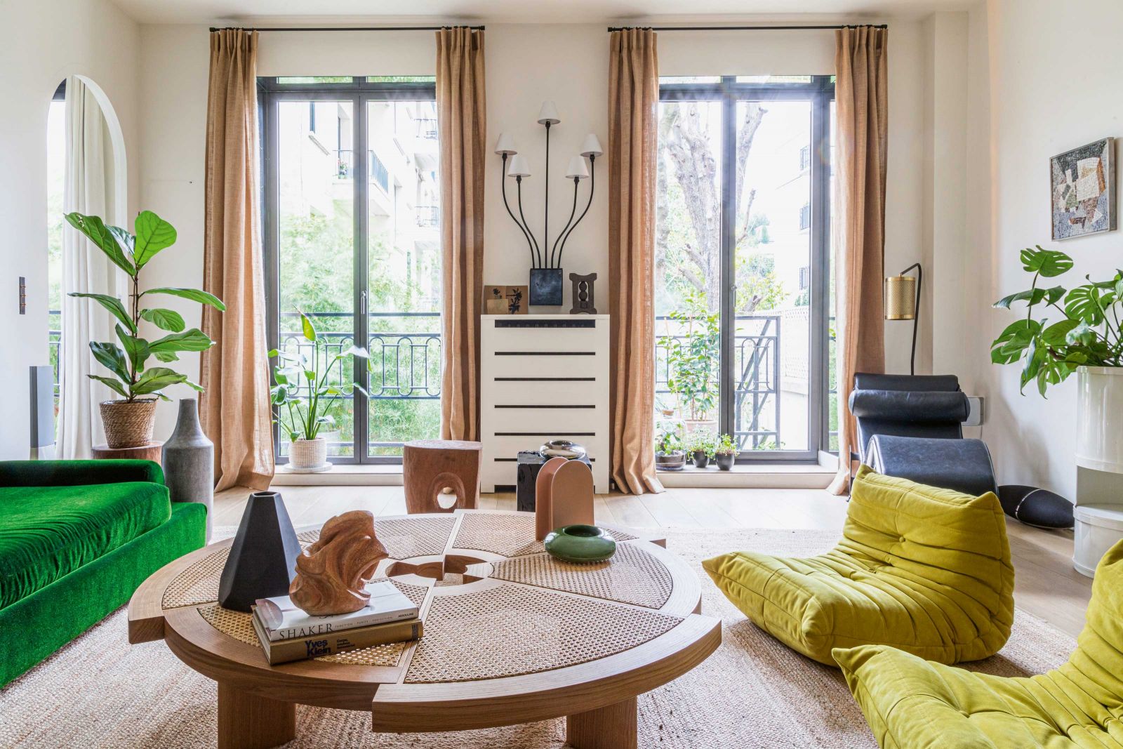 Im Wohnbereich treffen persönliche Gegenstände auf Kunst und Designklassiker. Auf dem Couchtisch «Rio» von Charlotte Perriand (neu aufgelegt von Cassina) steht eine Skulptur von Yvette Hauvette, Samanthas Grossmutter, und der Aschenbecher «Smoking No Smoking» von India Madhavi. Sessel: «Togo» von Ligne Roset; Stehleuchte: CTO Lighting; Hocker: Pols Potten.