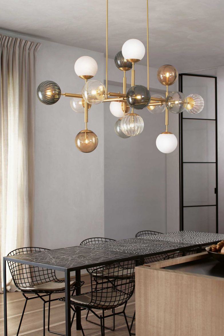 Die Deckenleuchte «Riegel» ist eine spielerische Anordnung von mundgeblasenen Kugeln, die wie Perlen auf einem Träger aus Messing aufgereiht werden. Die Leuchtkörper gibt es entweder alle in der gleichen oder in unterschiedlichen Ausführungen wie Opalglas, geripptem Glas, Marmor- oder Borosilikat-Glas. SCHWUNG.DESIGN / LICHTTEAM.CH