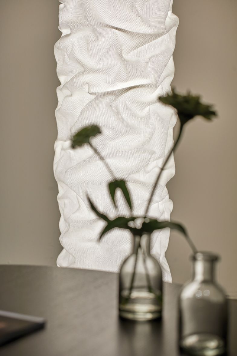 Das hochtechnische Innenleben der Leuchte wird von den sinnlichen Stofffalten eingehüllt.