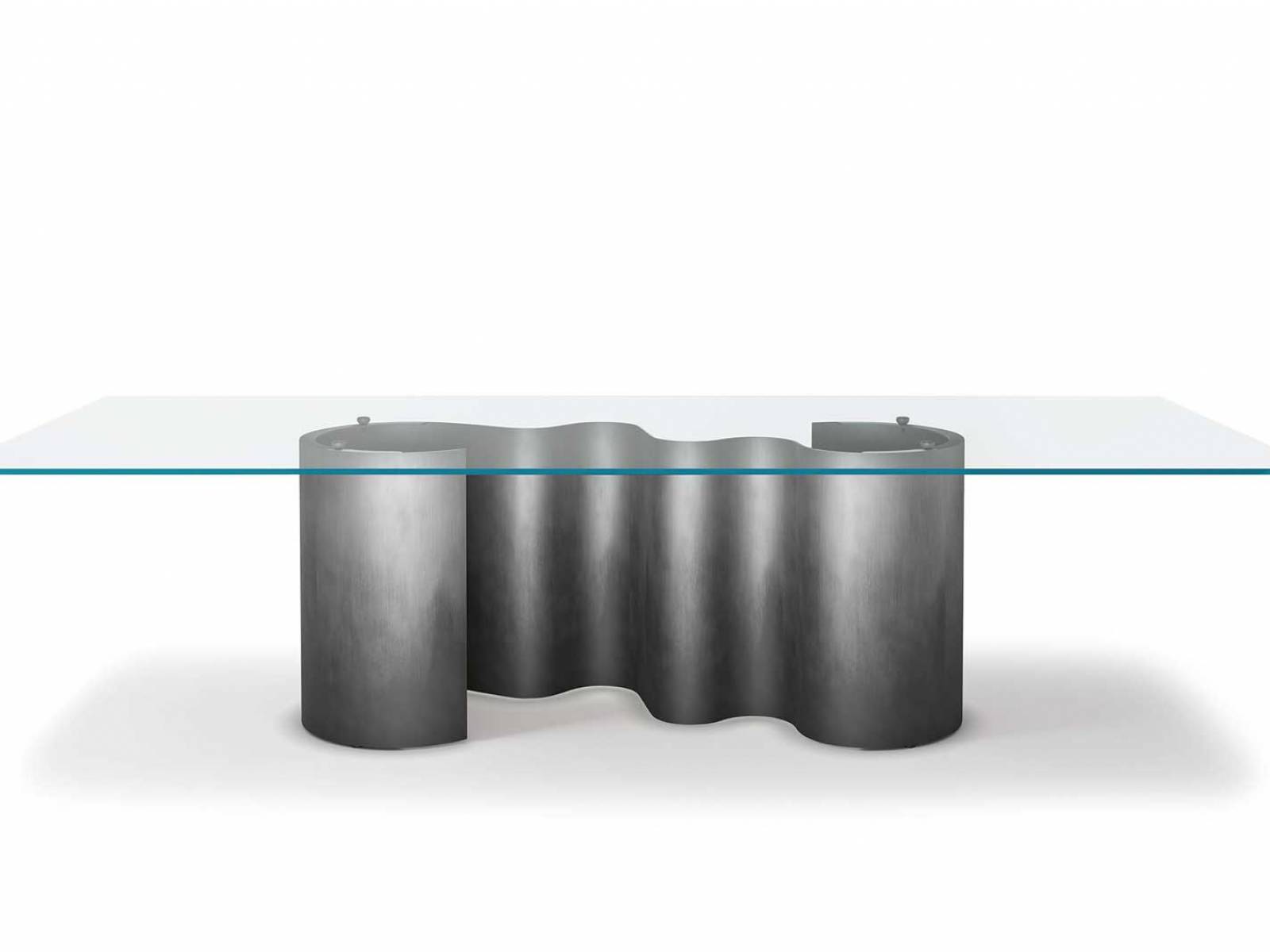 Die Tischfamilie «Papel» fängt die Dynamik von Meereswogen in einem filigranen Tischbein ein. Dieses besteht aus grazil geformtem Blech und schlängelt sich unter Tischplatten aus Holz, Keramik oder Glas. CATTELAN ITALIA.