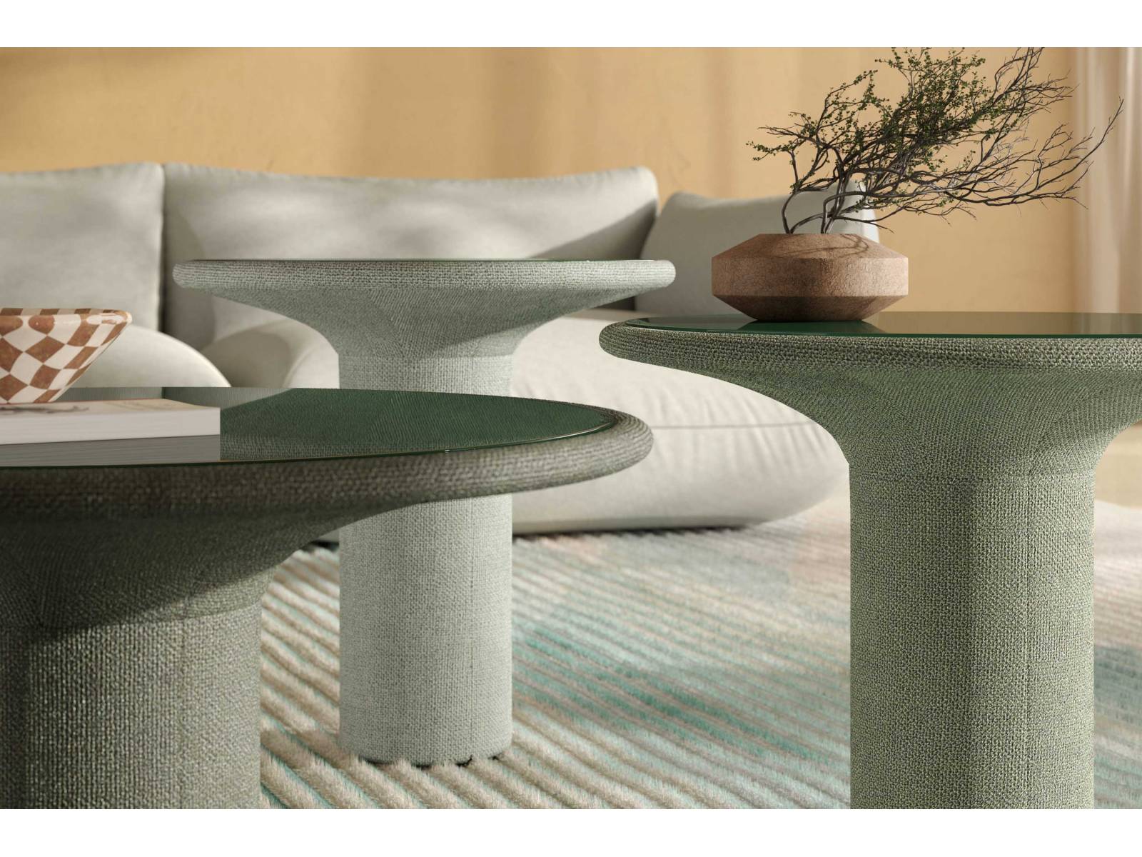 Der Designer Lukas Heintschel hat seinen Beistelltisch «Echo» in Textil gehüllt. Der kelchförmige Korpus ist wahlweise mit Stoff oder Leder bezogen, ganz ohne harte Kanten. Einen schönen Kontrast bildet die Platte aus Glas, die sich zum Reinigen leicht herausnehmen lässt. COR.