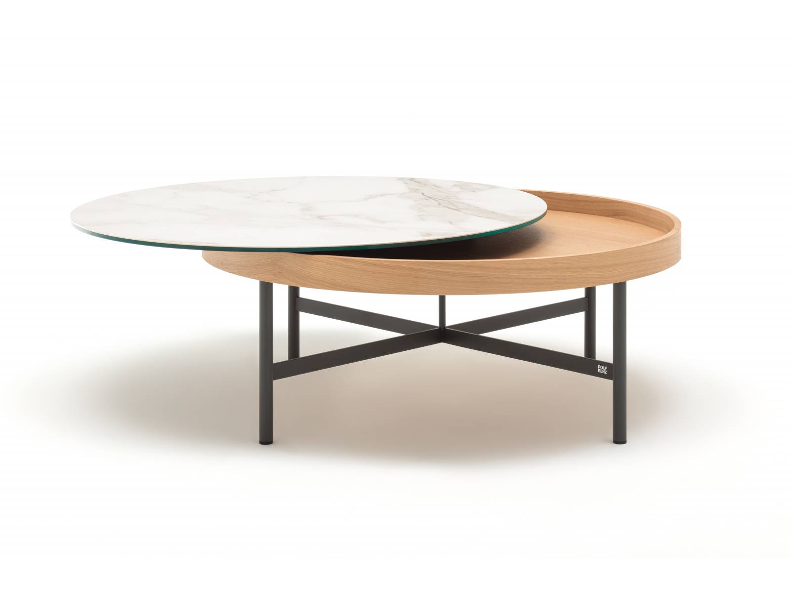 Wird zum Dreh- und Angelpunkt jeder Lounge-Ecke: Die Platte des runden Couchtischs »8290» lässt sich sowohl drehen wie auch zur Seite schieben, um den darunterliegenden Stauraum zu öffnen. Platte, Korpus und Gestell können in verschiedenen Farben und Materialien kombiniert werden. Rolf Benz.