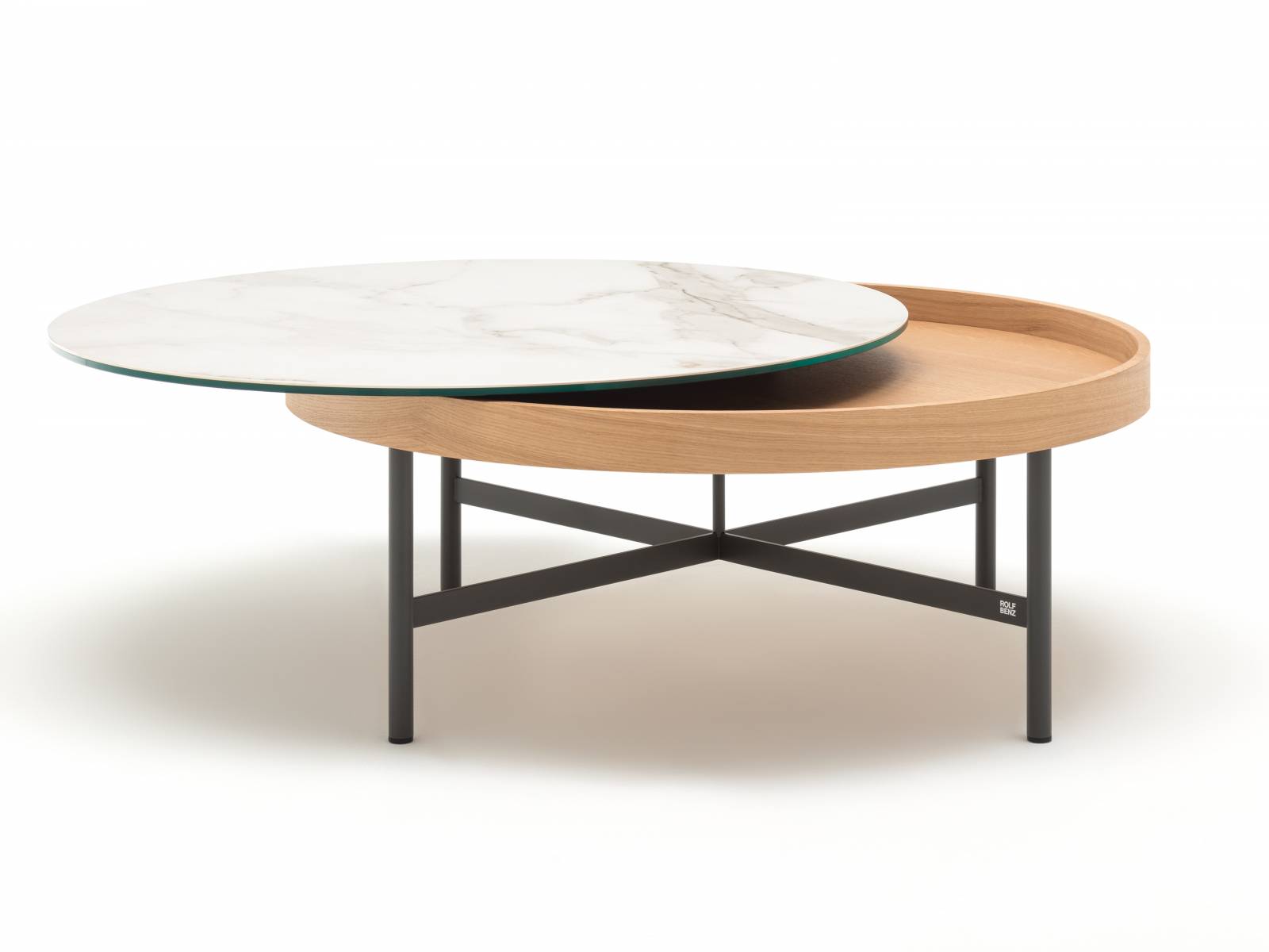 Wird zum Dreh- und Angelpunkt jeder Lounge-Ecke: Die Platte des runden Couchtischs »8290» lässt sich sowohl drehen wie auch zur Seite schieben, um den darunterliegenden Stauraum zu öffnen. Platte, Korpus und Gestell können in verschiedenen Farben und Materialien kombiniert werden. Rolf Benz.