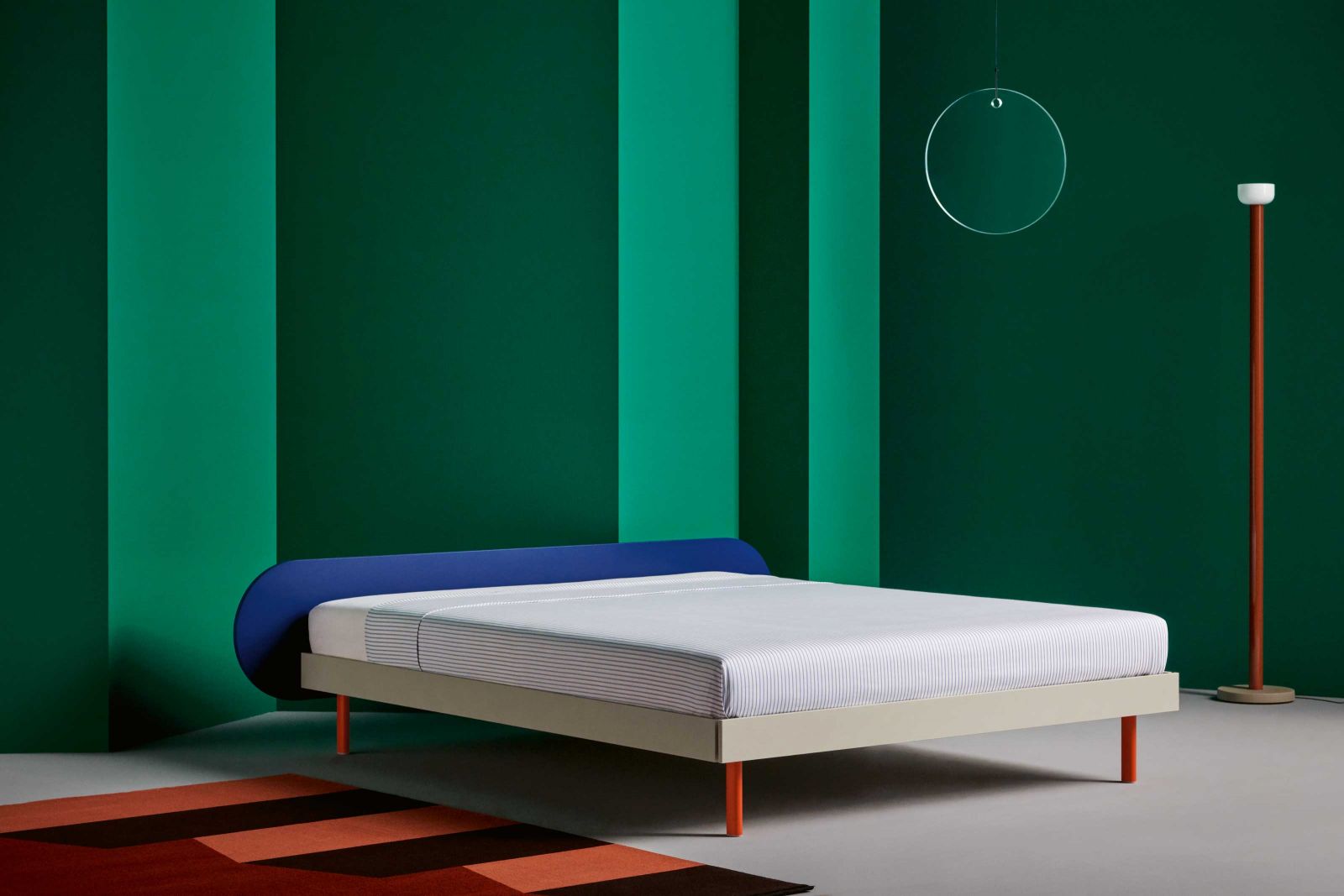 Bunt und farbig wie ein Sneaker ist diese Version von «Aluma» – das organische Betthaupt in frischem Blau steht im Kontrast zu den Beinen in Orange. Wer es lieber zurückhaltend mag, wählt die Variante in «Sand» oder den eckigen Header aus furnierter Esche. Foto: Studio Willen.