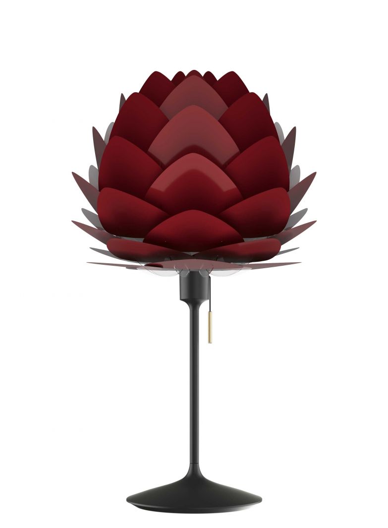 «Aluvia» präsentiert sich mit ihrem blütenförmigen Lampenschirm als ästhetische Lichtquelle in acht verschiedenen Farben und zwei Ausführungen. Während die hier gezeigte «Aluvia Mini» in Rubinrot auf dem Nachttisch Platz findet, eignet sich die Stehleuchte, um den gesamten Raum stimmungsvoll auszuleuchten. UMAGE.
