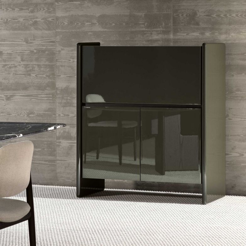 Hannes Peer hat in seinem Stauraummöbel «Logan» schlichte Anmut und skulpturale Schönheit auf raffinierte Weise miteinander verbunden, was sich vor allem in der besonderen Verbindung zwischen den geformten Seitenteilen und der vertieften Tischplatte zeigt. Die Kombination unterschiedlicher Materialien wie Holz und Marmor ist ein weiteres stilistisches Merkmal. MINOTTI.COM