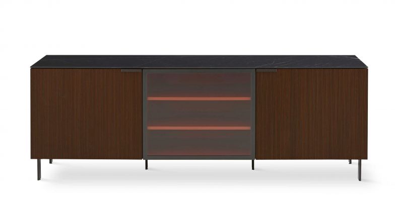 Fronten und Seiten in dunklem, geriffelten Nussbaum­furnier sind das Erkennungsmerkmal der Kollektion «Selvans», die in Anlehnung an das erfolgreiche Kastenmöbelprogramm «Everywhere», ebenfalls von Christian Werner, entstanden ist. Jetzt gibt es das Sideboard auch in schwarzer Esche und mit Glastüren im Mittelteil. LIGNE-ROSET.COM