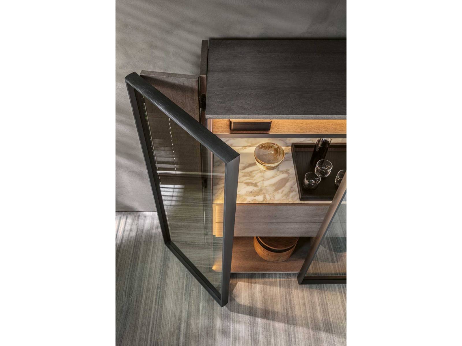 Materialien wie Eiche, Goldmarmor und Glas zeichnen das edle Aufbewahrungsmöbel «Hori-zons» aus. Eine LED-Beleuchtung im Inneren taucht das Möbel in einen warmen Ton. Die beiden Klapptüren lassen sich über zwei Seiten öffnen und ermöglichen so vollen Zugang zum Innenraum. Design: Dante Bonuccelli. Molteni.